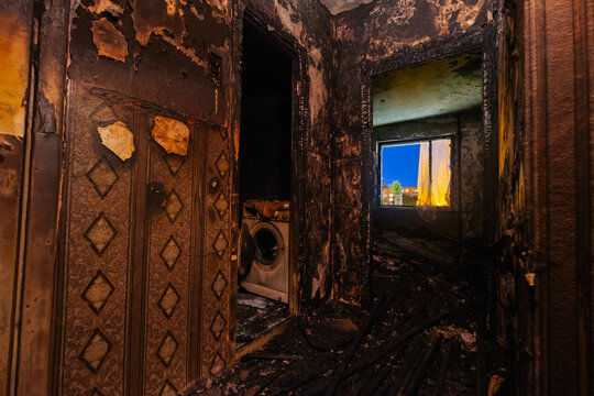 Burnt house interior. Fused remains of furniture and washing machine.