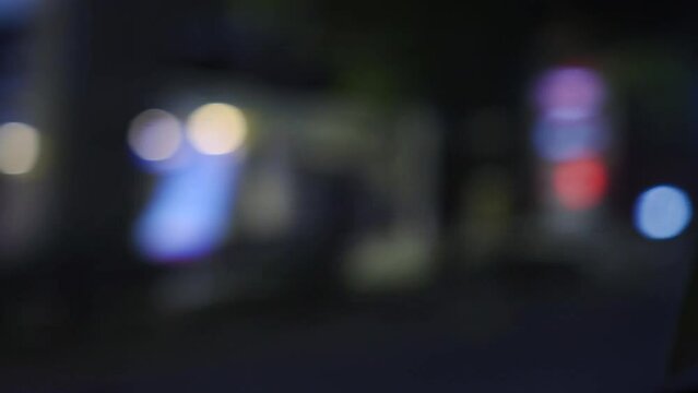 Defocus look of bangkok street at night. Car passing by with speed and beautiful light bokeh. Amazing Thailand nightlife. Using for green screen background scene.