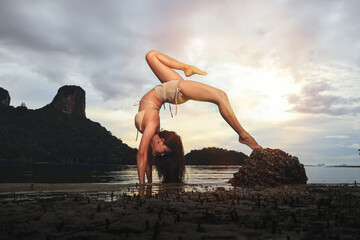 Young woman doing sport yoga on the beach, beautiful yoga pose on beach