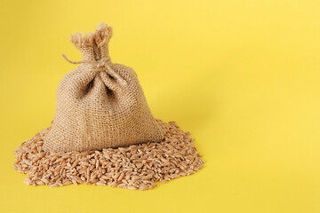 Fototapeta na wymiar Wheat, grain in a bag, on a yellow background. Harvest concept. Export Import. Food crisis during the war, sanctions