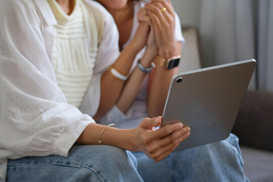lgbtq, lgbt concept, homosexuality, two beautiful women in love happily playing tablet in a cozy home