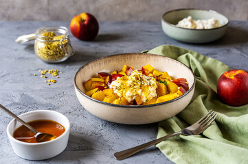 Healthy fruit salad with nectarine, ricotta cream with pistachios and honey