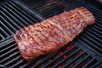 Traditionelles amerikanisches Barbecue Bavette Steak vom Wagyu Rind als close-up auf einem Holzkohlegrill mit Feuer