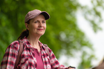 An attractive adult woman in casual clothes looks into the distance with a slight smile on her face.