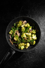 Dish Fried vegetables with mushrooms in a non-stick pan. Broccoli, spinach, onion in olive oil. Cooking healthy food.