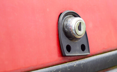 Old car trunk lock. Trunk lock details. Close-up of a handle to open the back door of a vintage red car