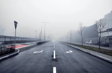 Fotobehang Asfaltweg in de mist in de stad. © badahos