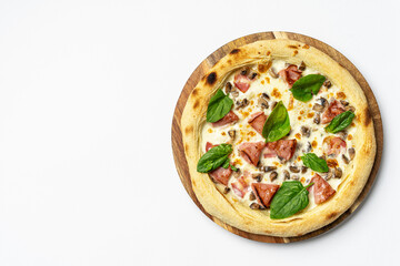 Tasty whole Italian pizza topped with thinly sliced prosciutto ham on the served restaurant table. Selective focus