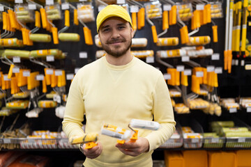 consultant recommends rollers and brushes for painting work in a hardware store