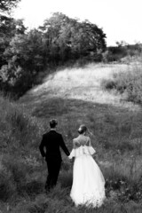 Black and white photo of a walking couple in nature holding hands