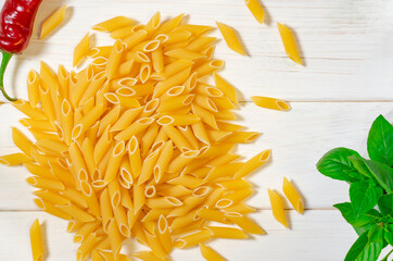 Penne Pasta, green basil, parmesan, sesame, garlic, chilli, eggs lie on a white tree table