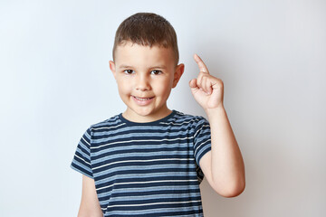 Little boy holds his hand up with his index finger. The concept of attention and caution.