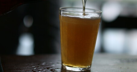 Person pouring beer into glass close-up, person serving alcoholic beverage and drinking