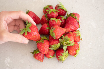 Fresh red strawberries on a marble tabletop in the kitchen. Harvest from the garden.