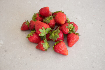 Fresh red strawberries on a marble tabletop in the kitchen. Harvest from the garden.