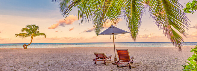 Beautiful beach panorama. Couple chairs sandy beach sunrise sea. Romantic summer holiday vacation for honeymoon tourism. Tropical sunset landscape. Tranquil palm leaves relax beach, island landscape