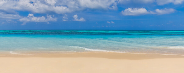 Closeup sand beach sea waves and blue summer sky. Panoramic beach landscape. Empty tropical beach...