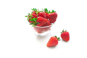 Fresh red strawberries in transparent bowl isolated on white background