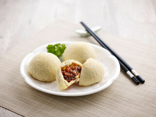 Crispy BBQ Honey Pork Bun with chopsticks Served in a dish isolated on wooden board side view on...