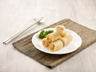 Crispy Vegetable Spring Roll Served in a dish isolated on wooden board side view on grey background