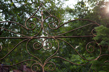 Fototapeta na wymiar wrought fence detail with green garden background