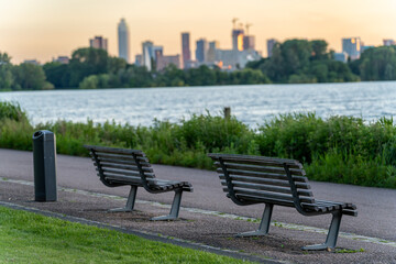 Empty bench in the park along the lake Kralingen, with blurred out skyline of Rotterdam in the...