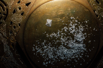 Maldon sea salt flakes with single pyramid shape salt crystal on hexagonal brass