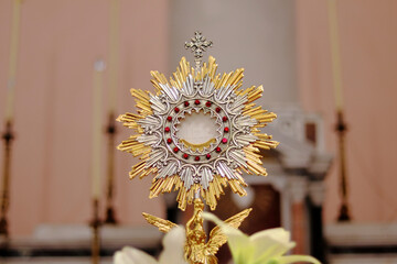 Ostensorial Adoration - Monstrance (Ostensory) with the Blessed Sacrament (Eucharist) on the Altar of the Church during Eucharistic adoration. The Host bears the inscription JHS, Jesus' name Monogram - obrazy, fototapety, plakaty