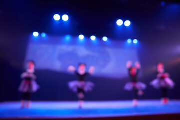A blurry abstract background of a dance festival from a group of girls in the number of four...