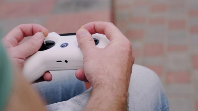 Closeup male hands remote control sticks of controller of FPV racing drone