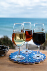 Tasting of Spanish sweet and dry fortified Vino de Jerez sherry wine and green olives with view on blue sea near El Puerto de Santa Maria, Andalusia, Spain