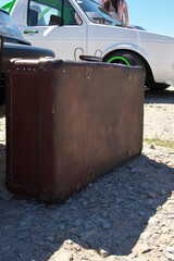 Vintage Suitcase on the background of a white car. The concept of travel by car. Selective...