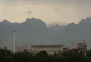 photograph of a building in china with some mountains in the background