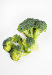 Broccoli florets on a white background. Green spring vegetables, isolated. Packshot photo, with a copy space.