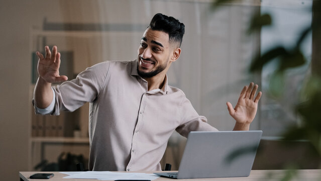  Happy funny male arabic businessman hispanic young guy millennial smiling man active dancing at home office has fun celebrate end of working enjoy exercises movement sing favorite song take job pause