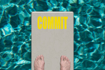 Swimming pool diving board with the word Commit.