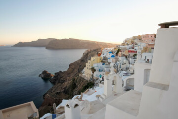 Fototapeta na wymiar View of the whitewashed and picturesque small houses and hotels of Oia Santorini