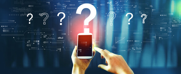 Question marks with person using a smartphone