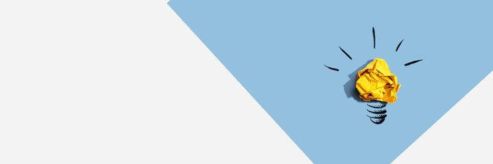 Brainstorming concept with a crumpled paper light bulb - Flat lay © Tierney