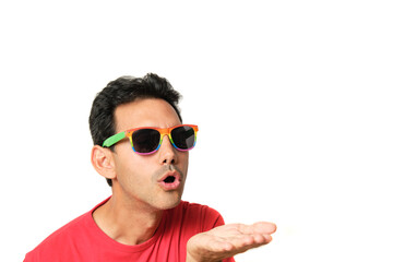 Dark-haired guy in red t-shirt blowing a kiss on his hand with lgbtq rainbow glasses