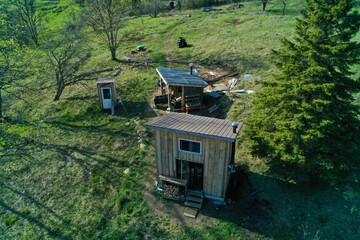 Aerial shot of an off-grid bunky in the woods during summer