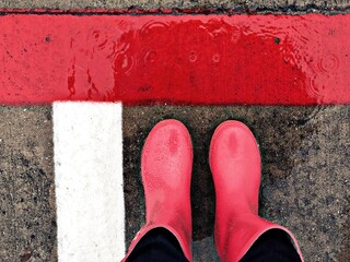 pink books, red and white lines on wet pavement on a rainy day