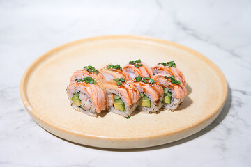 Close-up shot of sliced shrimp, salmon, avocado and green onion rolls on a plate, selective focus