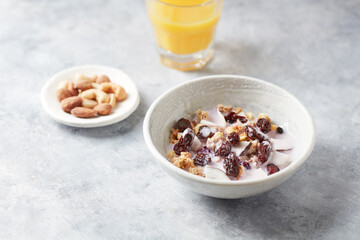 Bowl of granola with yogurt, nuts, cranberry and cocoanut. Concept for a tasty and healthy meal. Stone  background. 