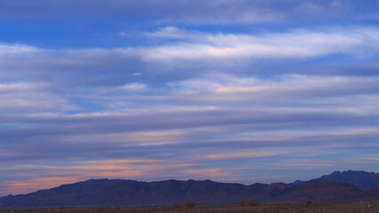 Tranquil Mojave Desert landscape scene with beautiful clouds shown at dusk.