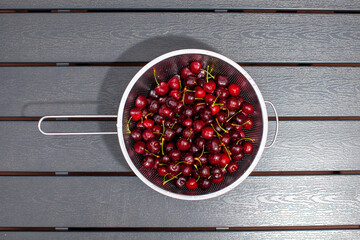 heap of fresh cherries in metal strainer
