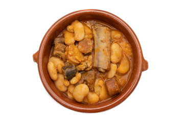 A terracotta plate with Asturian fabada, a typical Spanish bean stew, on a white background. Spanish food concept.