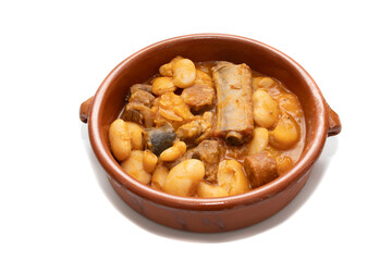A terracotta plate with Asturian fabada, a typical Spanish bean stew, on a white background. Spanish food concept.