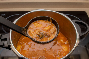An open pressure cooker with a bean stew, viewed from above. Spanish food concept. Typical Asturian Fabada stew.