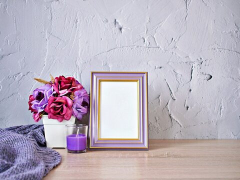 Empty photo frame with artificial yellow rose on wood table purple candles cement texture background gray color ,copy space for lettering ,Valentine's day ,love concept ,celebrate classic elegant card